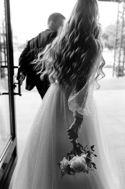 A captivating black-and-white photo of a bride and groom exiting together, creating a timeless wedding memory.